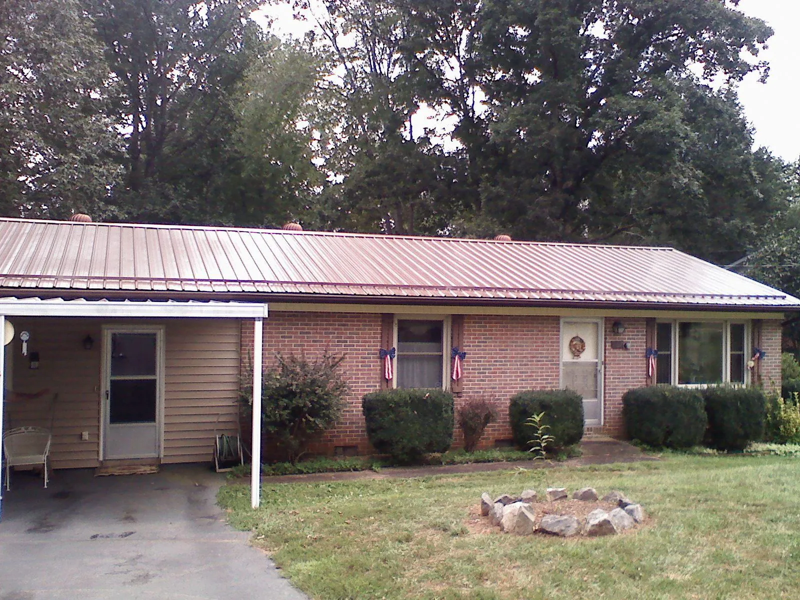 Bronze metal roof and carport on a brick ranch home in Columbiaville